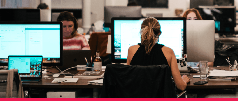 People in office using computers opposite each other