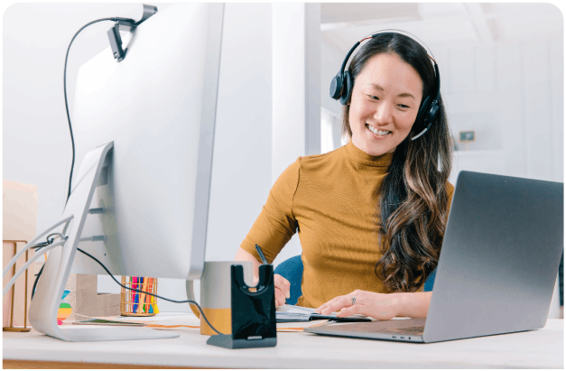Woman using Zoom wearing headset at laptop